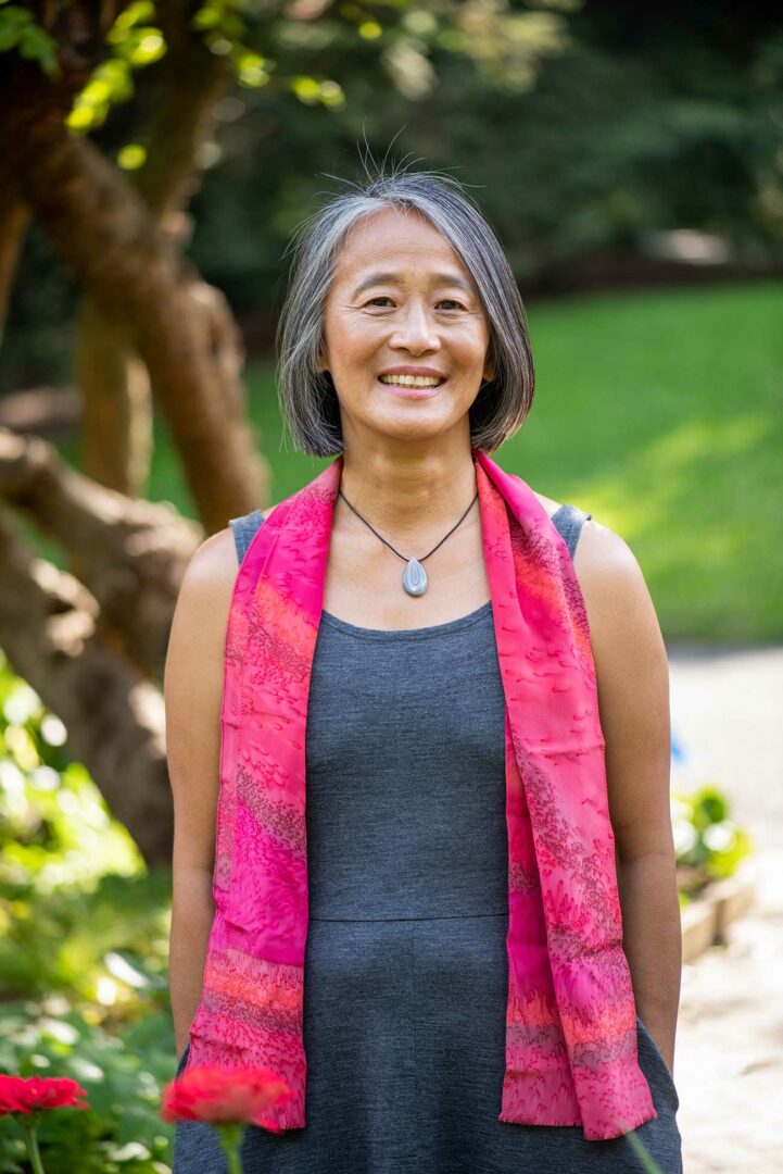 A woman standing in front of some trees