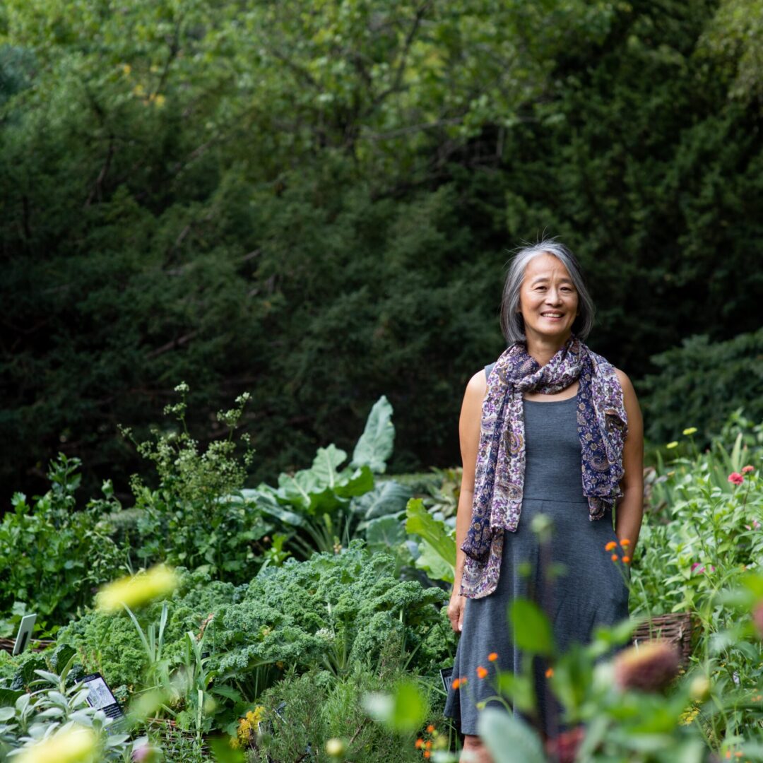 A woman standing in the middle of some plants