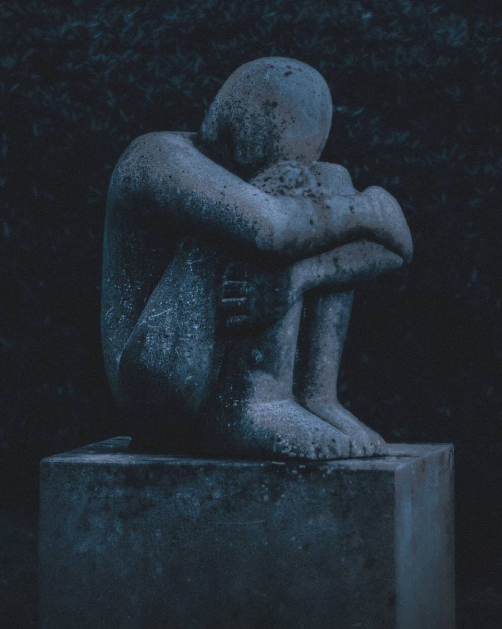 A stone statue in a fetus position