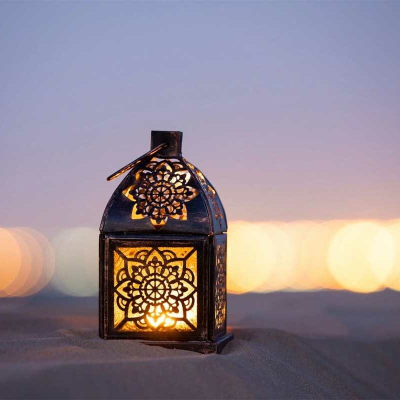 A lantern sitting on top of the sand.