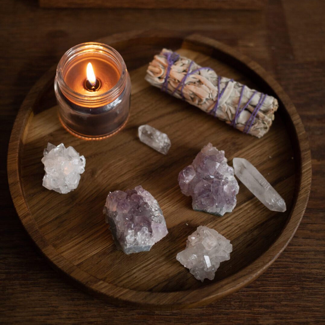 A candle and some rocks on a wooden plate